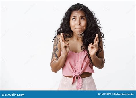 nervous cute curly haired african american woman in pink top with tattoos suck lips and