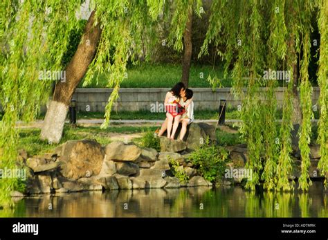 A Couple Embracing At A Lake Within The Grounds Of Beijing University