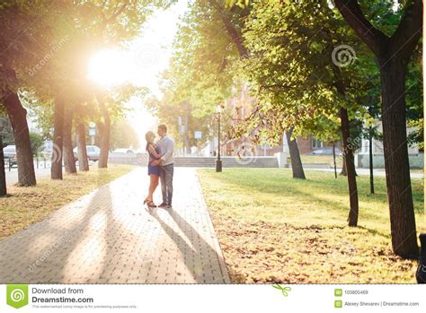 Beautiful Couple In Love With A Woman Walking In A Park On A Bench