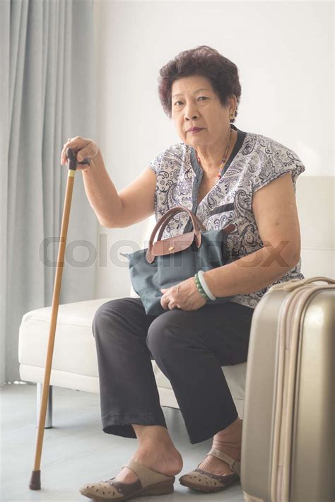 asian senior woman sitting at home and ready to travel stock image colourbox