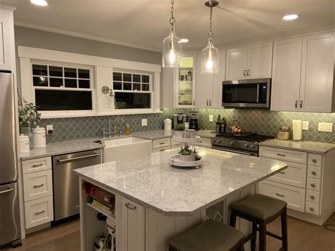 Inspect the interior of kitchen wall cabinets. Quartz counter, white shaker cabinets, glass pendant ...