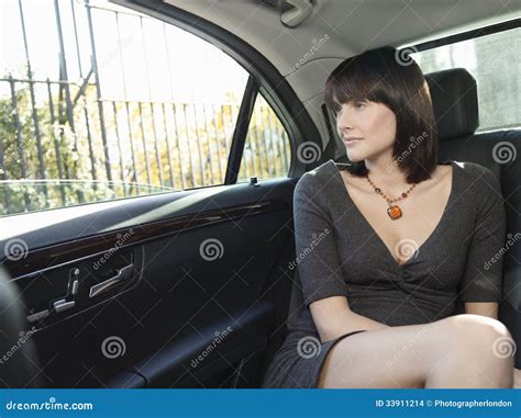 Businesswoman In Back Seat Of Car Looking Out Window Stock Images