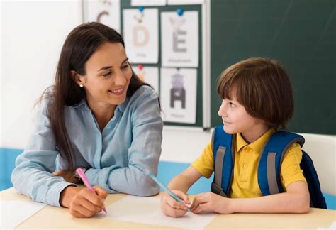 Maestra Hablando Con Su Alumno En Clase Foto Gratis