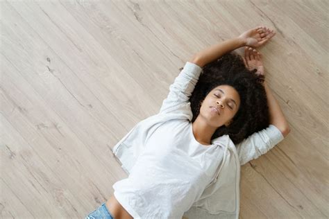 65833304 Upper View Of Woman Lying On The Back On Wooden Floor A