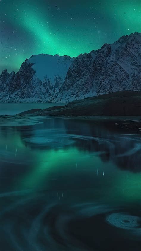 Snow Covered Mountains Near Body Of Water During Nighttime Under