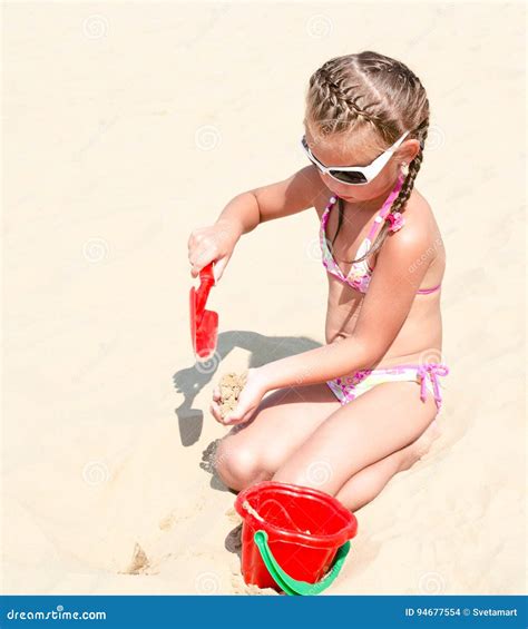 nettes lächelndes kleines mädchen das auf strand spielt stockfoto bild von sonnenbrille