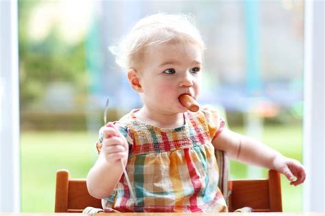 Funny Little Girl Eating Sausage From Fork — Stock Photo © Cromary