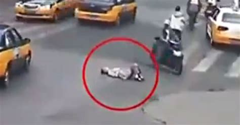 disturbing footage shows moment elderly woman is run over by car after lying down in middle of
