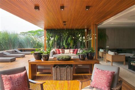An Outdoor Living Area With Couches Tables And Plants On The Roof Top Deck