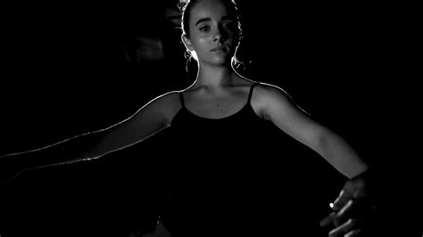 Portrait Professional Young Ballerina Standing In Spotlight On Black