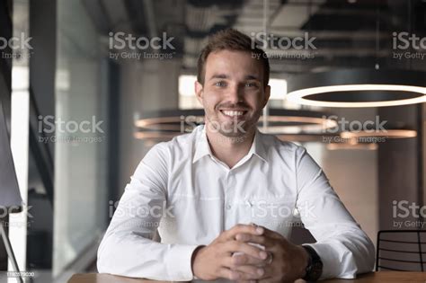 Portrait Of Smiling Male Employee Posing In Office Stock Photo