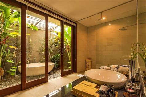 A Bathroom With A Large Tub Next To A Walk In Shower And Glass Doors Leading To The Outside
