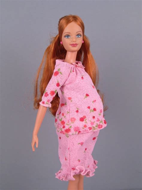 a doll with red hair wearing a pink dress