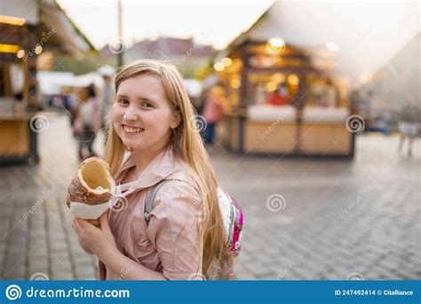 Smiling Modern Girl At Fair In City Eating Trdelnik Stock Photo Image