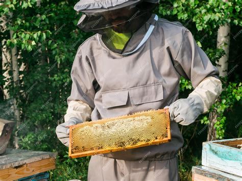 Premium Photo Beekeeper Removing Honeycomb From Beehive Person In Beekeeper Suit Taking Honey