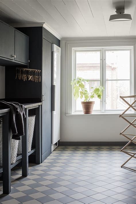 What to put in a gift wrap basket? Black cabinetry in the laundry room with checkered floor ...