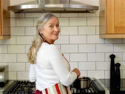 Older Woman Cooking In Kitchen Stock Photo Dissolve