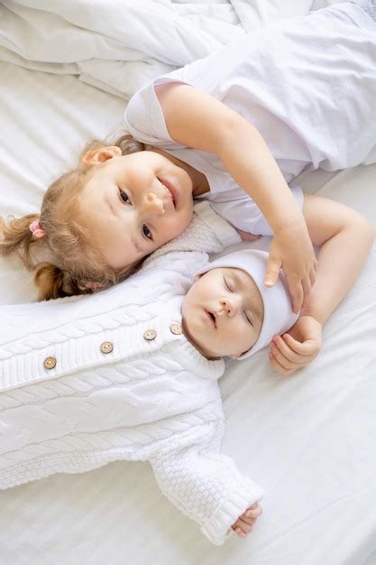 Una Niña Abraza A Una Hermana O Hermano Recién Nacido Dormido En Una