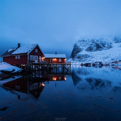 Norway Log Cabin Traditional Rorbu Cabin Reflects In Fjord In Evening