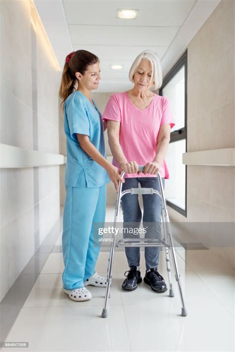 Nurse Helping Senior Patient In Using Mobility Walker High Res Stock