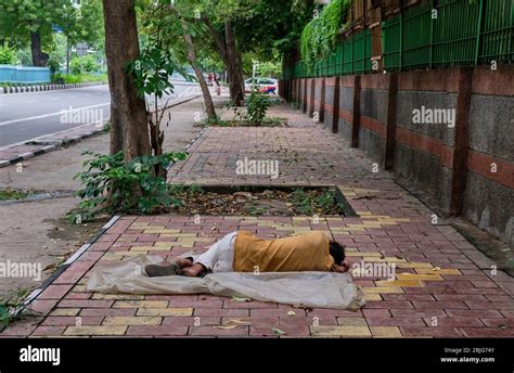 Poor Homeless Man Sleeping On Sidewalk In New Delhi India Stock Photo