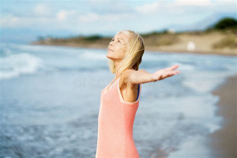 Beautiful Older Female Spreading Her Arms On A Beautiful Beach
