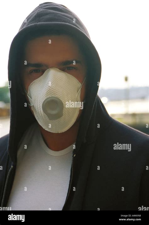 Man Wearing Hooded Sweatshirt And White Dust Mask Over Nose And Mouth