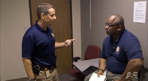 two men in blue shirts are talking to each other