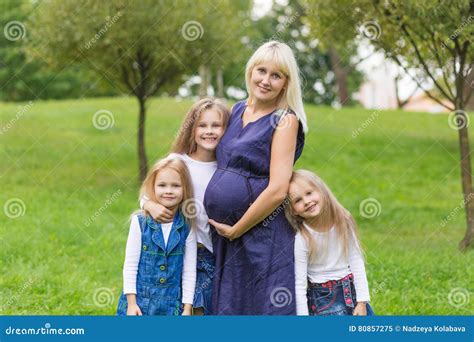 Schwangere Mutter Der Junge Mit Ihrer Familie In Einem Park Stockbild