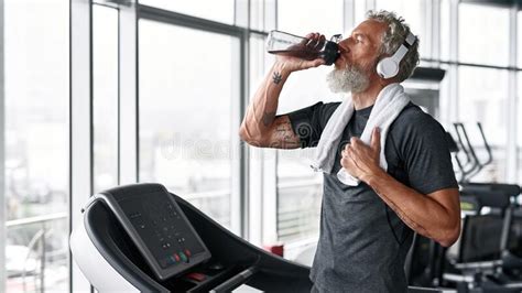 Mature Man Drinking Water From Bottle The Towel On Shoulder Stock