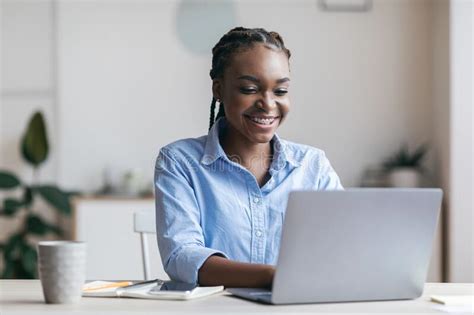 Young Black Secretary Working On Laptop In Modern Office Typing On