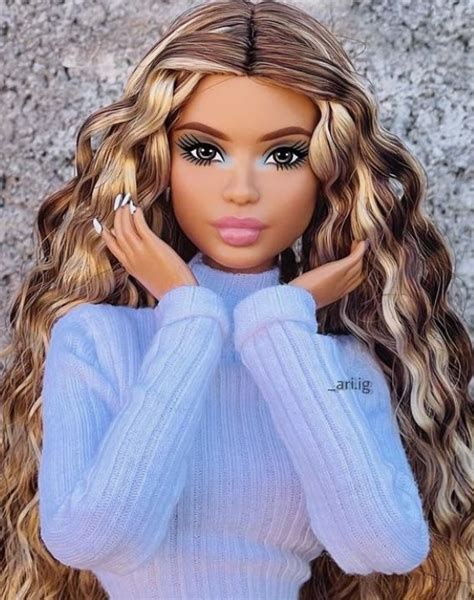 A Barbie Doll With Long Blonde Hair Wearing A Blue Sweater And Silver Ring On Her Finger
