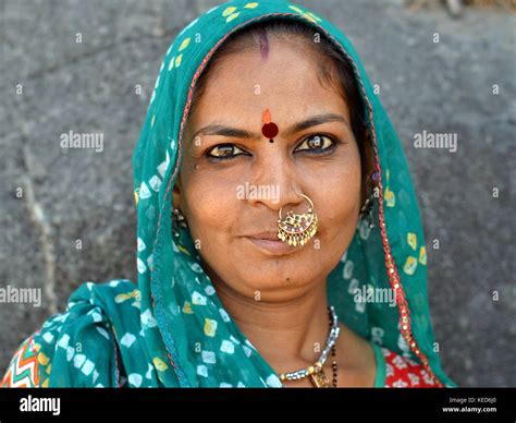 foto de cabeza de una mujer gujarati de mediana edad con dupatta verde y joyas de nariz indias