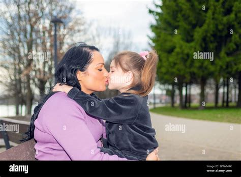 Cute Years Old Girl And Her Mom Kissing In A Park Bench In Summer
