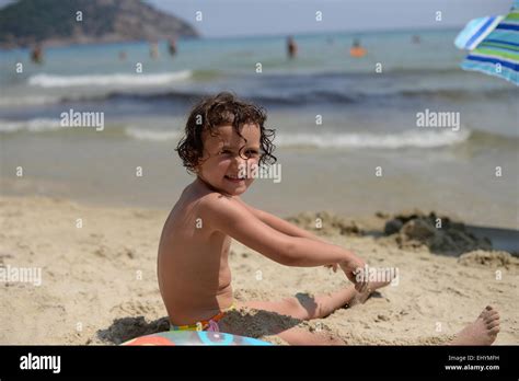 Smiling Girl Playing In The Sand On The Beach Thassos Greece Stock Photo Alamy