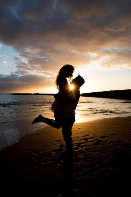 Premium Photo Boyfriend Lifts His Girlfriend On The Beach During