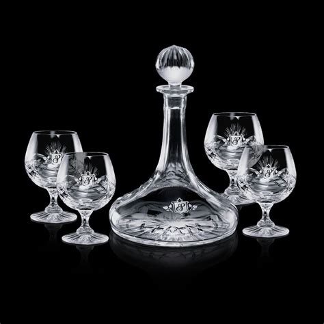 Four Wine Glasses And A Decanter On A Black Background