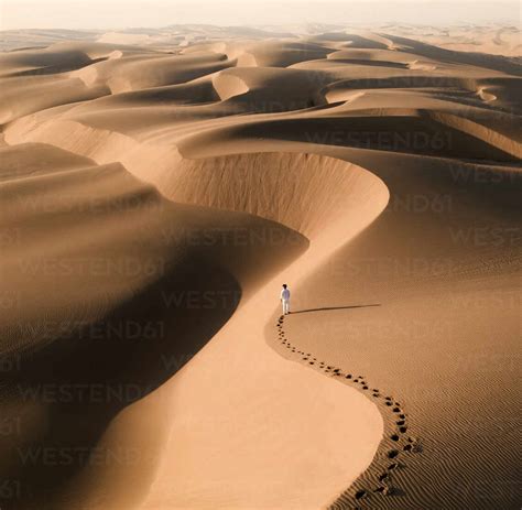 Aerial View Of Man Walking At Sand Dunes At Sandwich Harbour Namibia