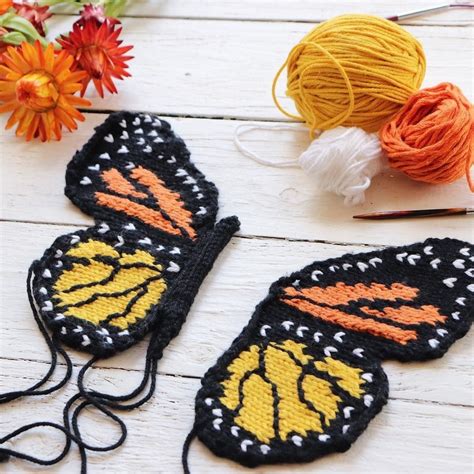 Two Crocheted Butterflies Sitting On Top Of A Table Next To Yarn And