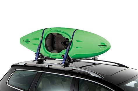 A Car With A Surfboard On Top Of Its Roof Rack And Two Kayaks Attached