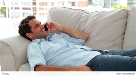 Casual Man Lying On The Sofa Chatting On The Phone Stock Video Footage