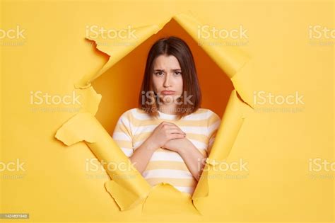 Portrait Of Sad Upset Woman Wearing Striped Shirt Posing In Yellow