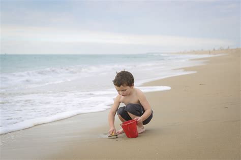 Photo Of Boy Digging Up Sand On The Beach By Karyn Olsson Click Magazine