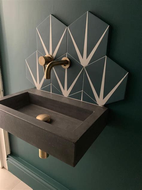 A Bathroom Sink Sitting Under A Mirror Next To A Wall Mounted Faucet