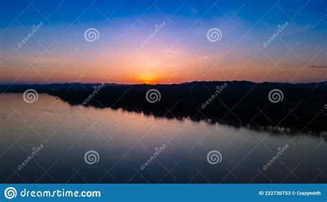 Landscape Sunset Sky Over River And Silhouette Mountain With Reflection