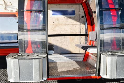 Red gondola ski cable way lift isolated with open door and empty seats