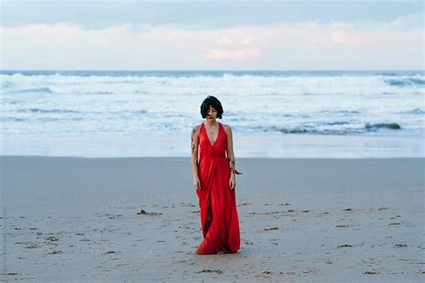 Portrait Of Woman With Red Dress And Tattoos On The Beach By Stocksy Contributor Thais Ramos