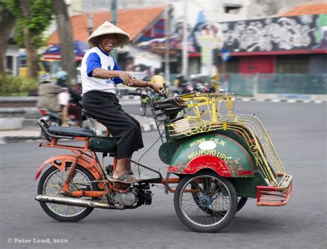 A Man Riding On The Back Of A Small Motorcycle
