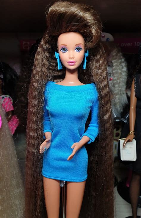 A Barbie Doll With Long Brown Hair And Blue Dress
