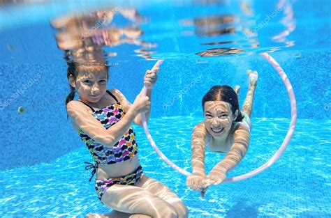 Happy Children Swim In Pool Underwater Girls Swimming Playing And